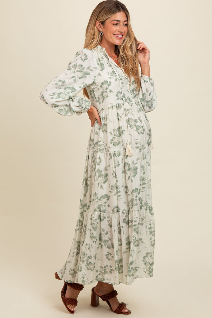 woman wearing a floral print maternity maxi dress with puff sleeves and a baby bump visible