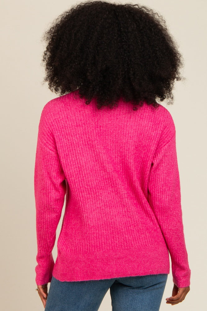 woman wearing a bright pink ribbed sweater from the back, paired with blue jeans