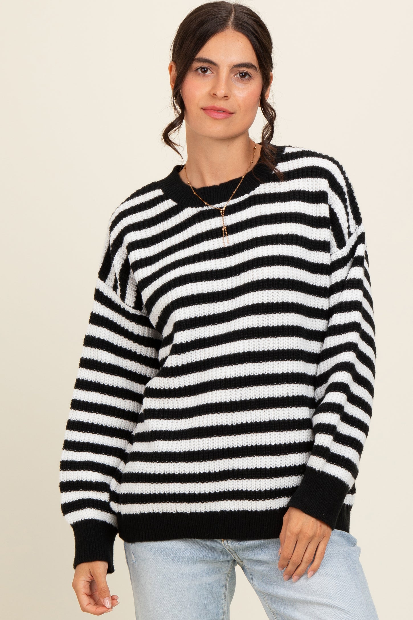 woman wearing a black and white striped oversized sweater with a relaxed fit and long sleeves