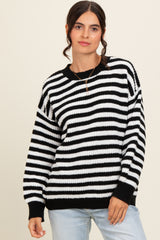 woman wearing a black and white striped oversized sweater with a relaxed fit and long sleeves