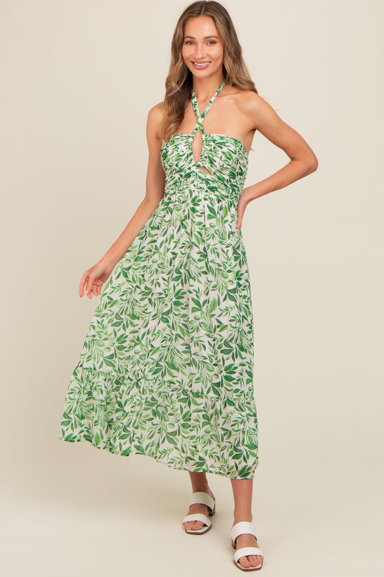 woman wearing a green floral halter neck maxi dress with a keyhole cutout and tiered skirt