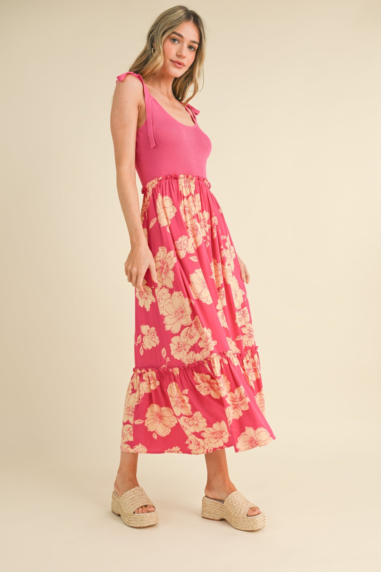 woman wearing a pink ribbed tank top and a long floral tiered maxi skirt with espadrille wedges