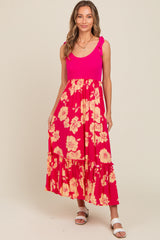 woman wearing a pink floral maxi dress with ruffled skirt and shoulder ties