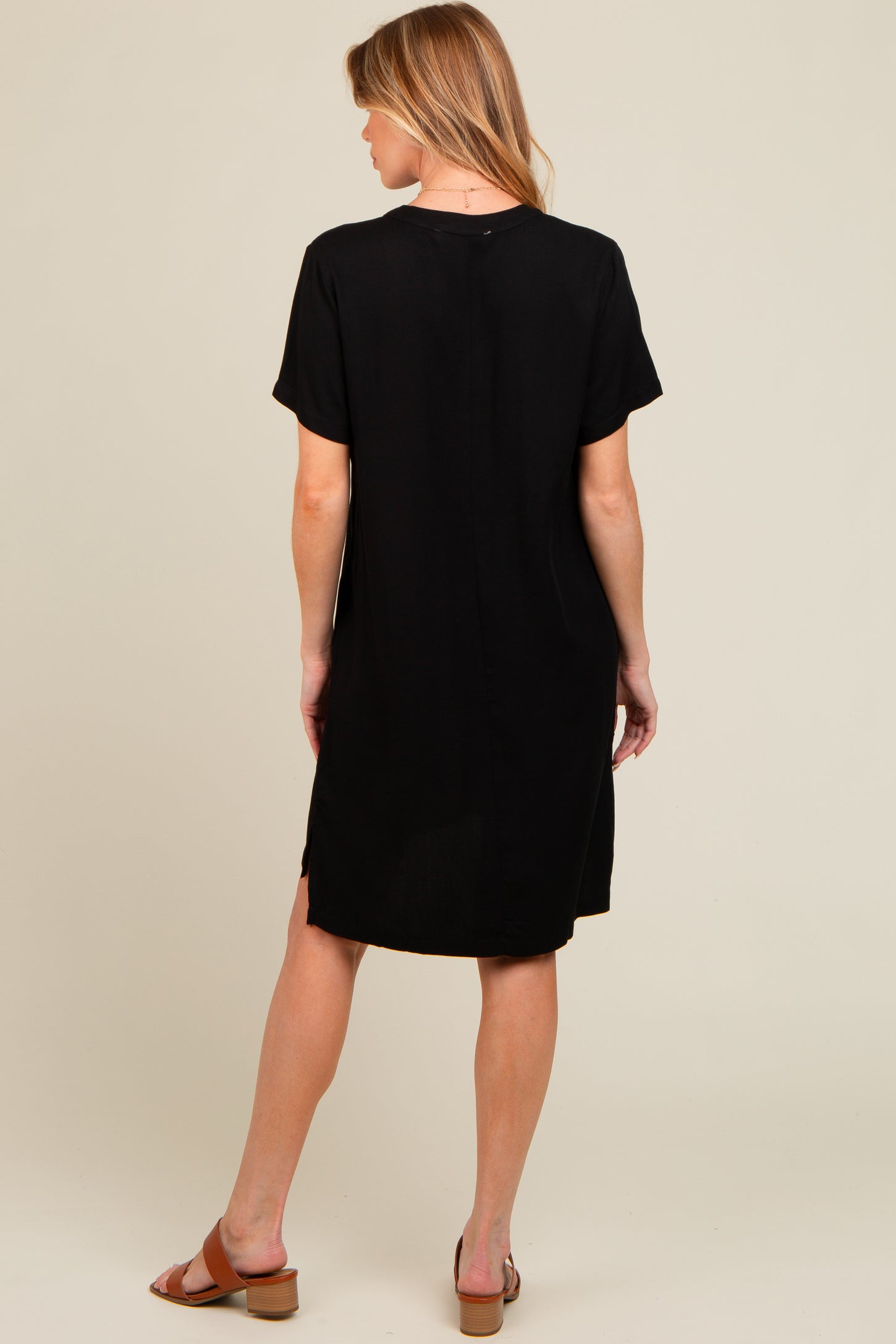 woman wearing a black short sleeve maternity dress, shown from the back