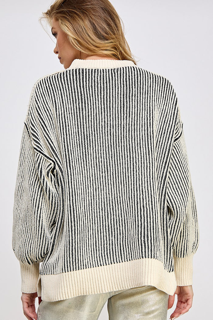 woman wearing a cream and black striped oversized sweater, showing the back view and puffed sleeves