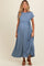 woman wearing a blue short sleeve maternity dress with a gathered waist and a flowing skirt, showing her baby bump