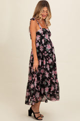 woman wearing a black floral maternity maxi dress with spaghetti straps and a visible baby bump