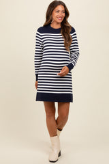 woman wearing a navy and white striped maternity dress with a relaxed fit and long sleeves, showing her baby bump