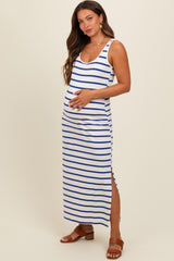 woman wearing a white and navy striped maternity maxi dress with a side slit and holding her baby bump