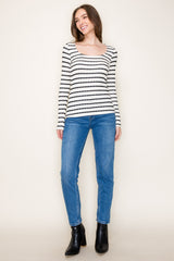 woman wearing a black and white striped long sleeve top paired with blue skinny jeans and black ankle boots
