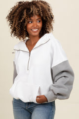 woman wearing a white and gray zip-up sweatshirt with a front pocket and puffed sleeves