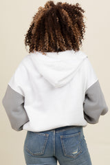 woman wearing a white and grey color block hoodie with a relaxed fit and a hood, viewed from the back