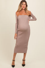 woman wearing a taupe ribbed off-shoulder maternity dress, showing her baby bump with one hand on her hip