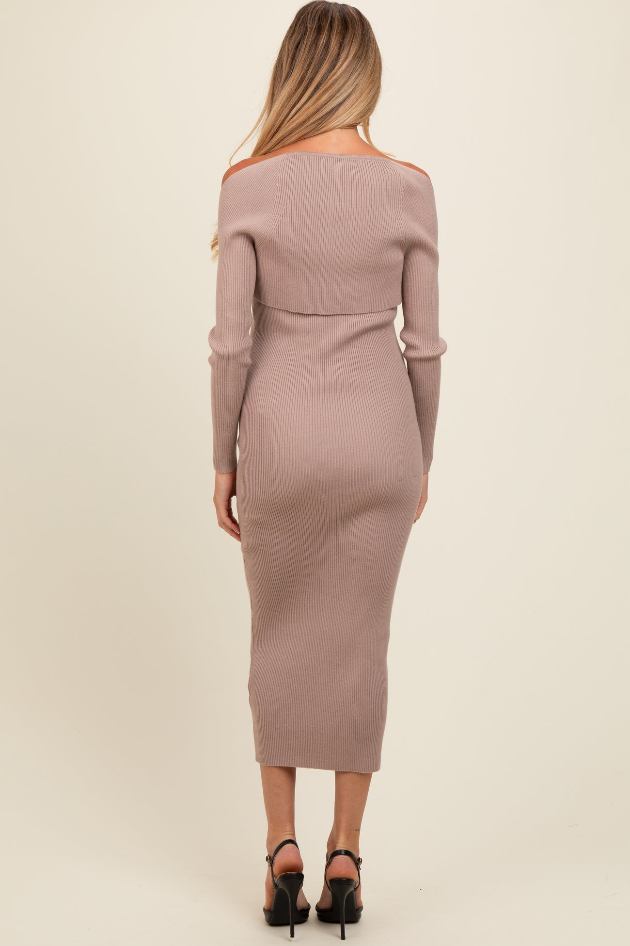 woman wearing a light mauve off-shoulder ribbed maternity dress, showing a fitted silhouette and long sleeves