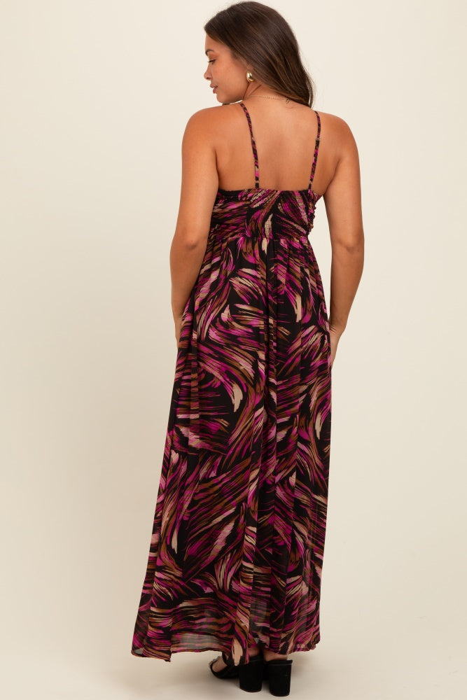 woman wearing a black and pink floral maternity maxi dress with adjustable straps and a flowing silhouette from the back