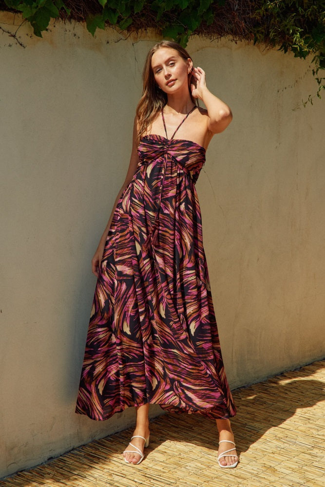 woman wearing a strapless maxi dress with a vibrant multicolor leaf pattern and a fitted bodice