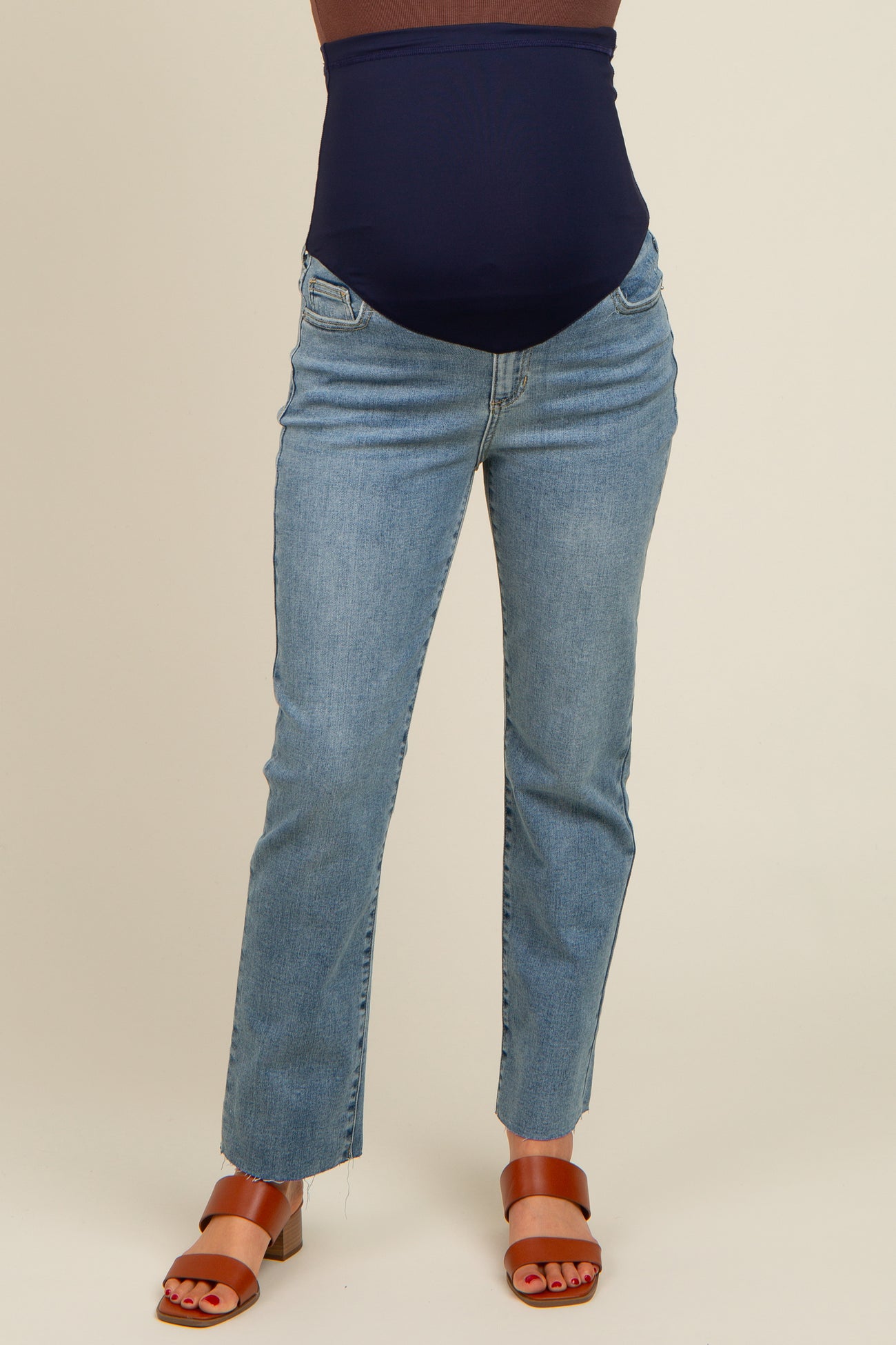 woman wearing dark blue maternity jeans with a high waist and straight leg cut, showcasing a baby bump