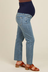 woman wearing light blue maternity jeans with a dark blue waistband and a visible baby bump