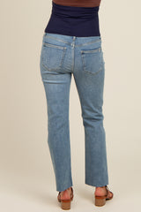 woman wearing light blue maternity jeans with a flared hem and a black top, shown from the back