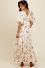 woman wearing a floral maxi dress with short sleeves and a tiered skirt, showing a back view