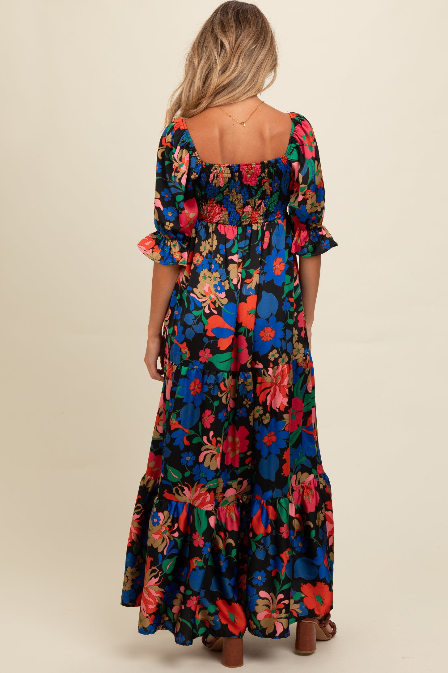 woman wearing a floral print black maternity maxi dress with puff sleeves and a smocked bodice