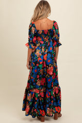 woman wearing a floral print black maternity maxi dress with puff sleeves and a smocked bodice