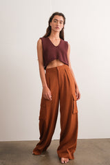 woman wearing a burgundy cropped sleeveless top and high-waisted brown cargo pants with side pockets