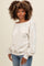 woman wearing a light beige off-the-shoulder sweater with balloon sleeves and light blue fitted jeans
