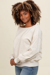 woman wearing a beige oversized sweatshirt with a relaxed fit and cuffed sleeves