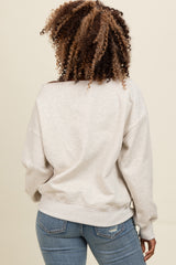 woman wearing a light gray off-the-shoulder sweatshirt and blue skinny jeans, showing the back view