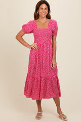 woman wearing a pink floral midi dress with puff sleeves and a square neckline