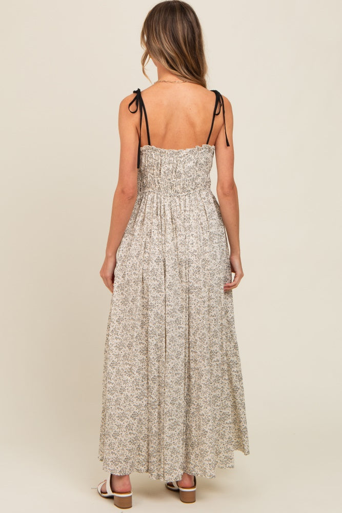 woman wearing a floral maxi dress with smocked bodice and adjustable tie straps, view from the back