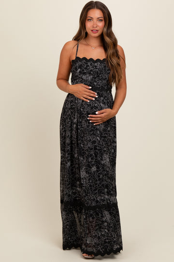 woman wearing a black floral lace maternity maxi dress and holding her baby bump