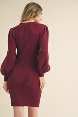 woman wearing a maroon ribbed sweater dress with puffed sleeves and fitted silhouette from the back