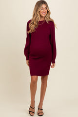 woman wearing a burgundy ribbed maternity dress with long sleeves and a baby bump visible