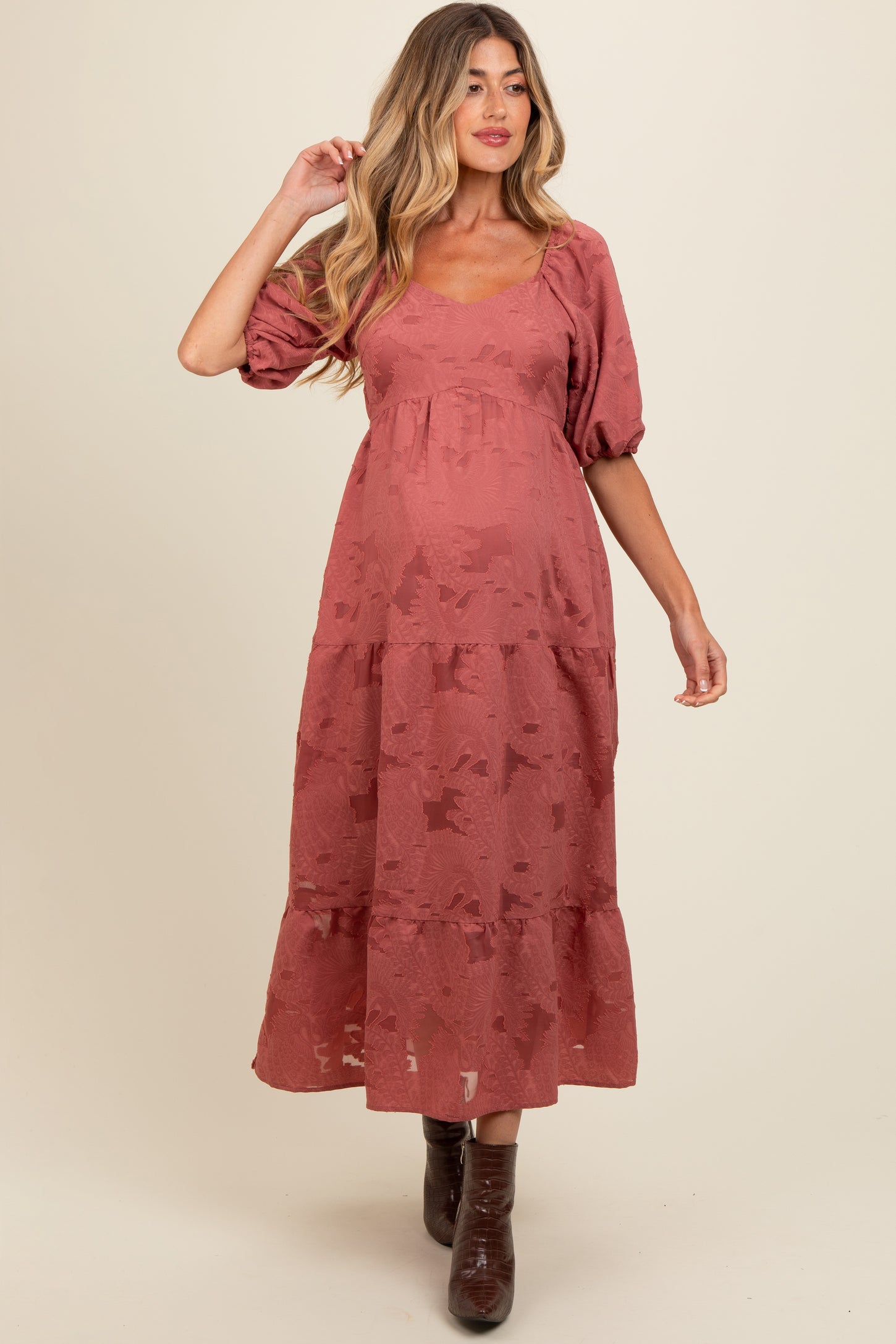 woman wearing a dusty rose maternity maxi dress with puff sleeves and tiered skirt, showcasing her baby bump