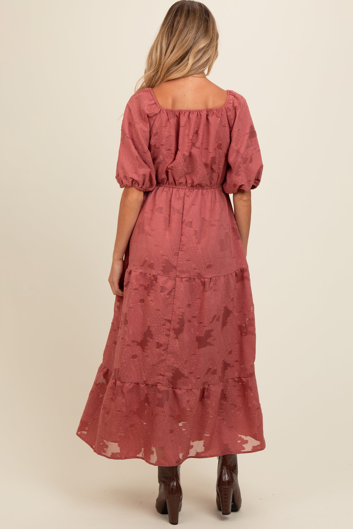 woman wearing a dusty rose maternity maxi dress with puff sleeves and tiered skirt, shown from the back
