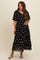 woman wearing a black floral maternity maxi dress and showing her baby bump