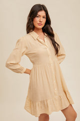 woman wearing a light beige striped button-up mini dress with long puff sleeves and tiered ruffle hemline