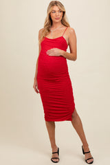 woman wearing a red maternity dress with ruched details and embellishments, holding her baby bump