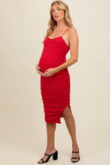 woman wearing a red maternity dress with ruching and sparkling details, holding her baby bump