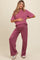 woman wearing a mauve ribbed maternity lounge set and holding her baby bump