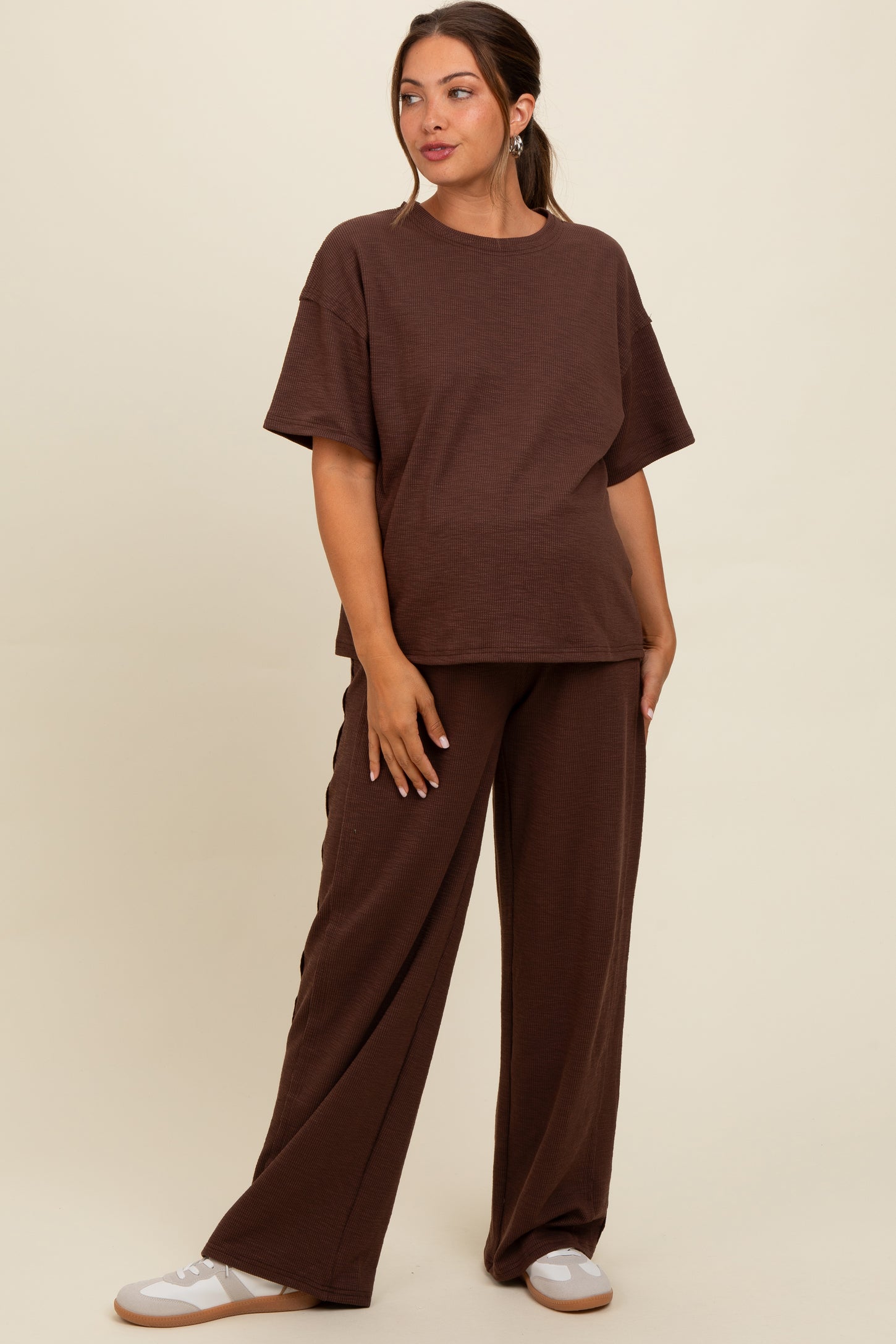 woman wearing a brown maternity loungewear set with loose-fitting top and wide-leg pants