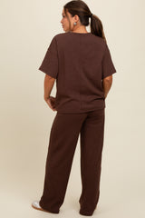 woman wearing a brown maternity lounge set with short sleeves and loose-fitting pants, showing the back view