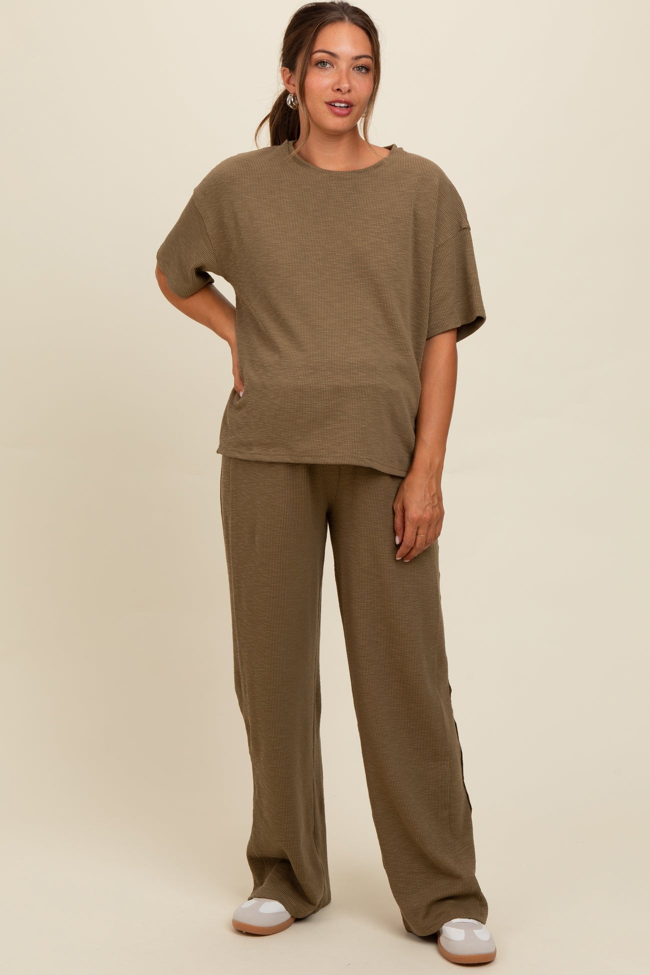 woman wearing a beige ribbed maternity top and matching wide-leg pants, showcasing a relaxed fit