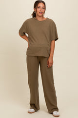 woman wearing a beige ribbed maternity top and matching wide-leg pants, showcasing a relaxed fit