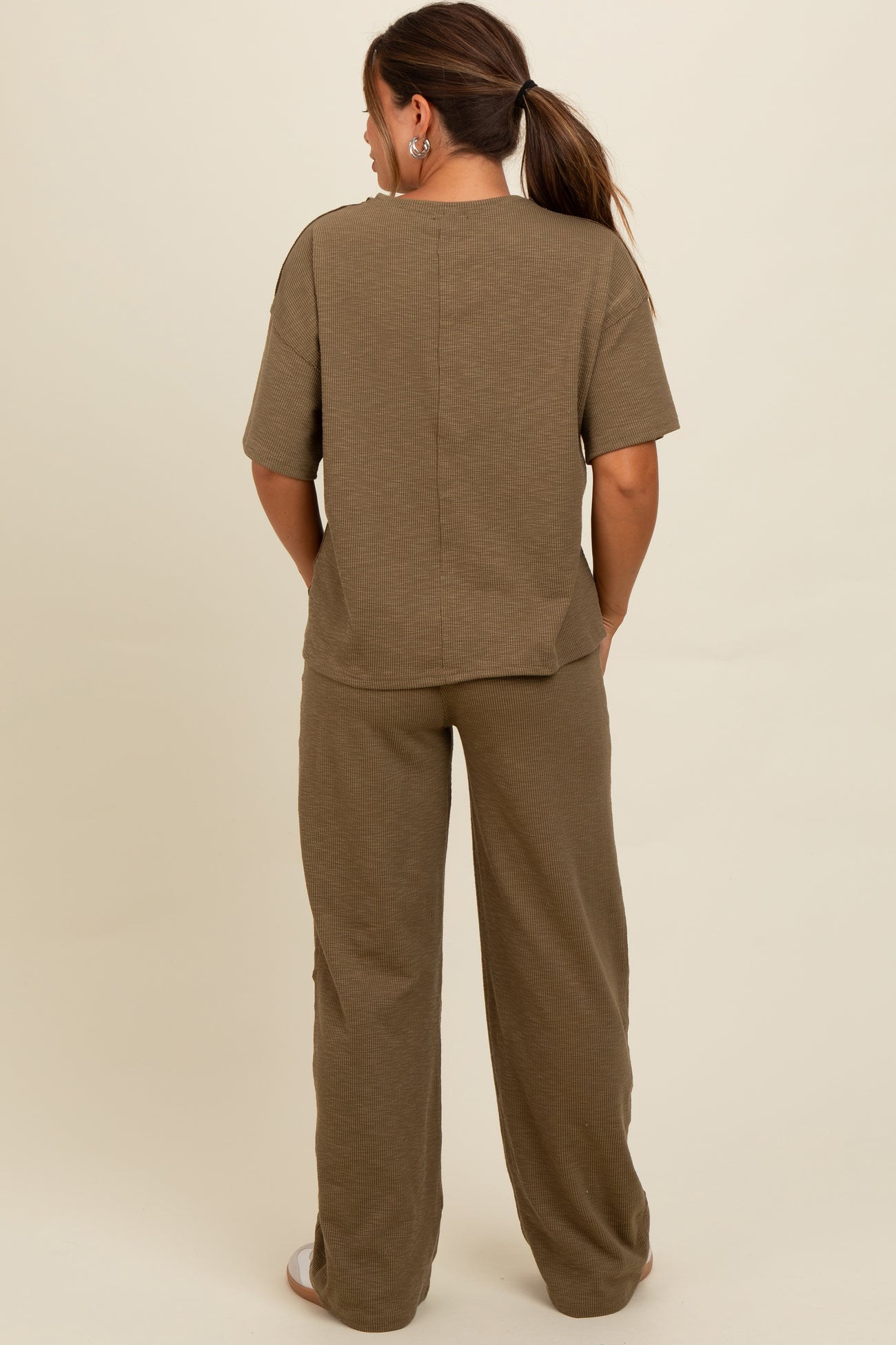 woman wearing a brown maternity loungewear set consisting of a short sleeve top and wide leg pants