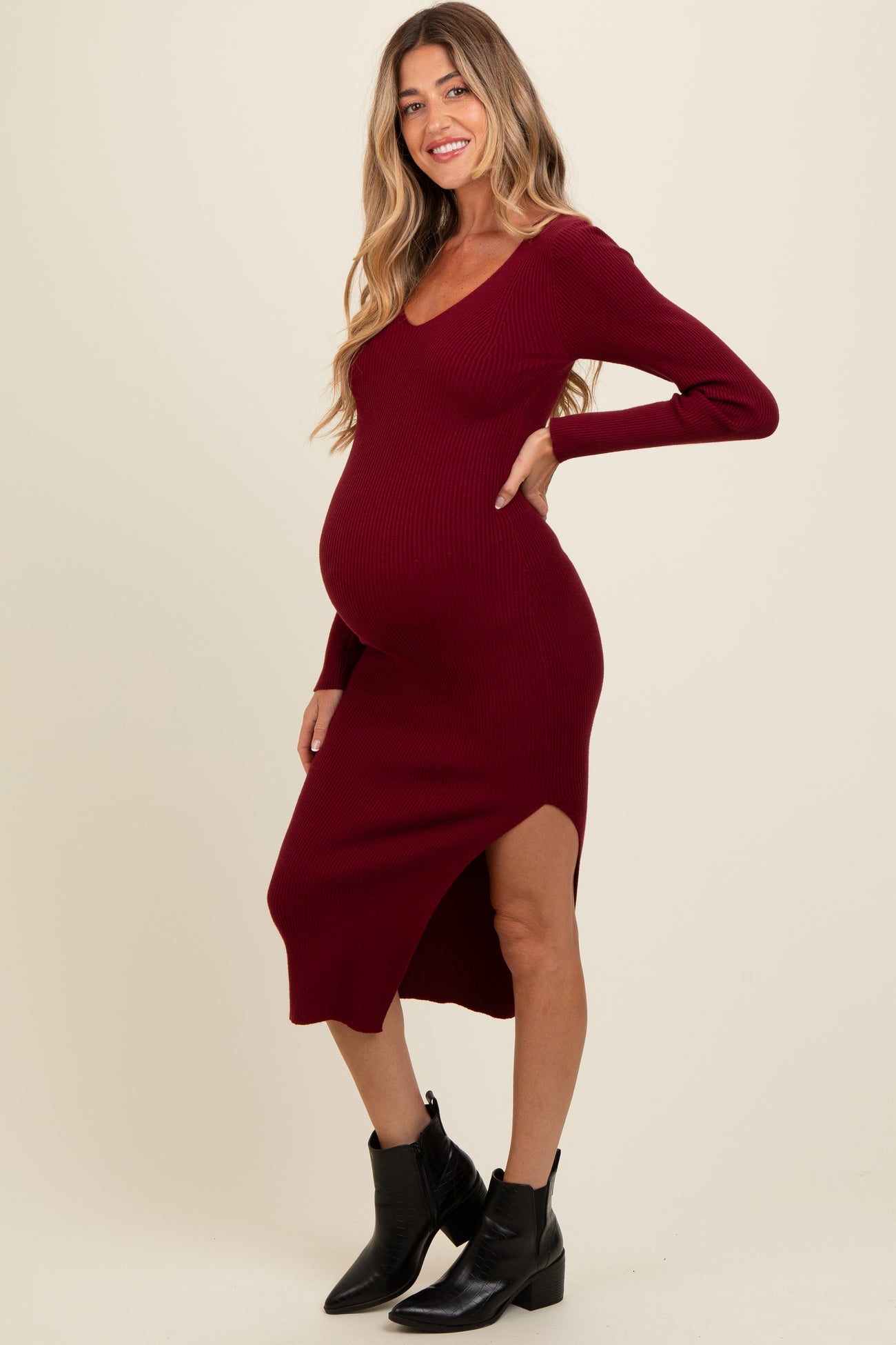 woman wearing a burgundy ribbed maternity dress with a side slit and a visible baby bump