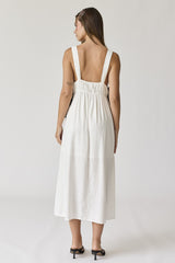 woman wearing a white sleeveless midi dress with a gathered back and simple straps