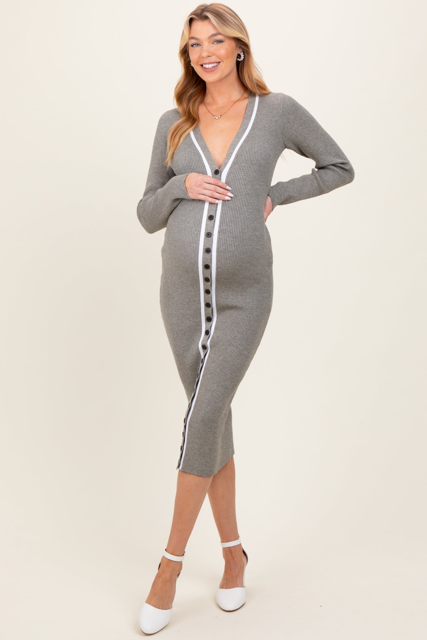 woman wearing a gray ribbed maternity dress with buttons and a deep v-neck, showing her baby bump while posing